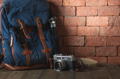 Close-up of vintage bag and camera on wall