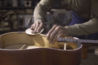 Midsection of man playing guitar