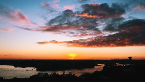 Scenic view of sea against cloudy sky at sunset