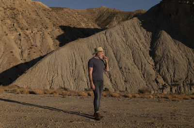Adult man in cowboy on desert against mountain. almeria, spain