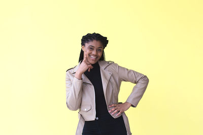 Portrait of smiling young woman against gray background