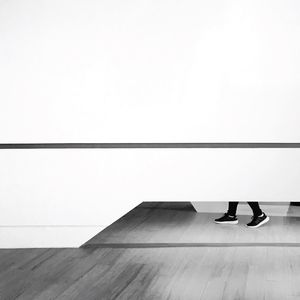 Low section of woman standing on hardwood floor