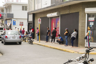 People on street against buildings in city