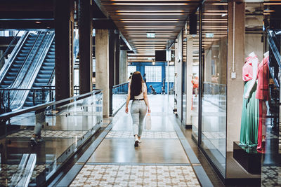 Modern latina young woman walking in large modern mall. young pretty brunette female consumer