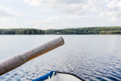 Close-up of boat on river against sky