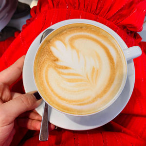 Midsection of person holding cappuccino