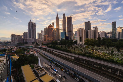 Aerial view of city buildings against cloudy sky