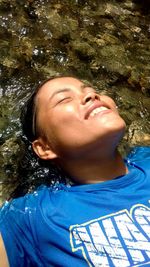 Close-up portrait of smiling young woman with eyes closed