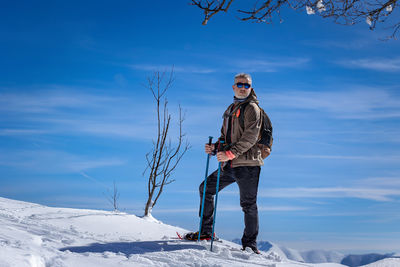 Full length of woman standing on snow covered mountain