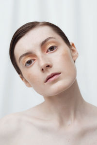 Close-up portrait of young woman over white background