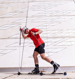 Side view of man with ski roller against wall