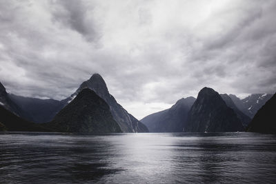 Scenic view of sea and mountains against sky