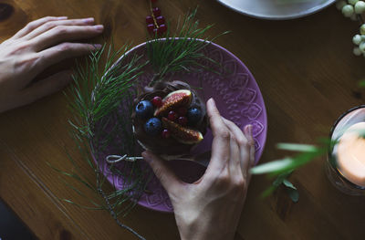 High angle view of woman holding ice cream on table