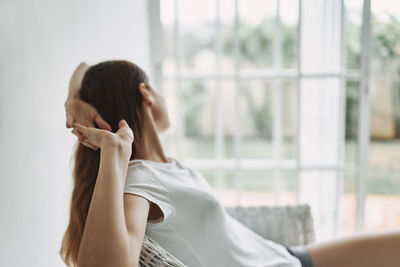 Portrait of woman sitting by window