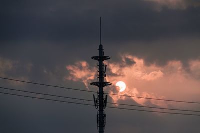 Low angle view of silhouette electricity pylon against sky during sunset