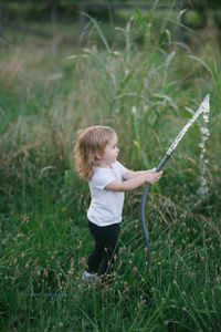 Rear view of boy standing on grassy field