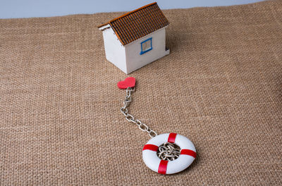Close-up of model home and keyring charm on jute