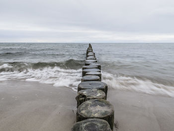 Scenic view of beach against cloudy sky