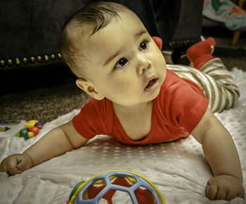 Portrait of cute boy playing on bed at home