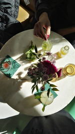 Close-up of hand holding flower on table