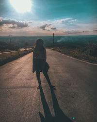 Rear view of woman walking on road in city