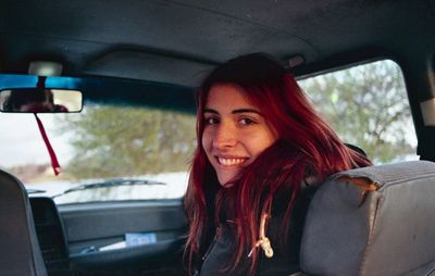 Portrait of smiling woman sitting in car