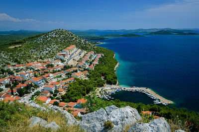 High angle view of townscape by sea against sky