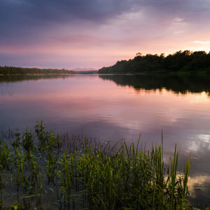 Scenic view of lake against sky at sunset