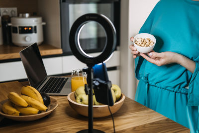 Midsection of woman holding coffee at table