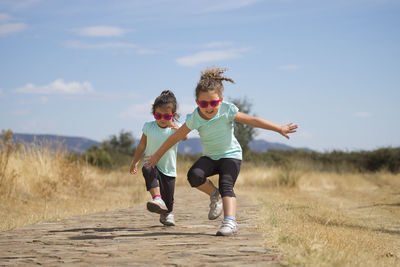 Full length of children on landscape against sky