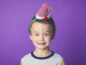 Boy wearing cap hat against purple background