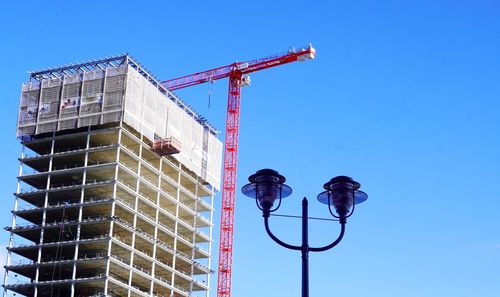 Low angle view of crane against building