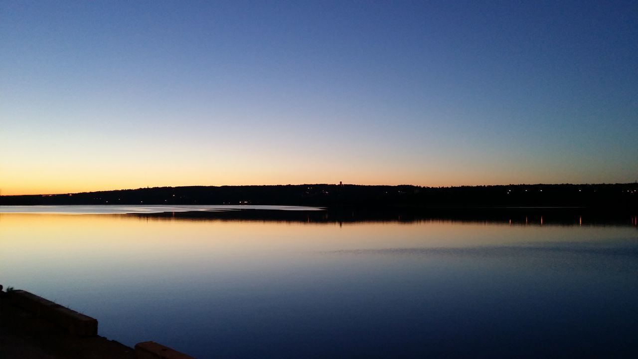 clear sky, copy space, water, sunset, reflection, tranquility, tranquil scene, silhouette, scenics, river, waterfront, beauty in nature, built structure, connection, lake, nature, dusk, bridge - man made structure, architecture, calm