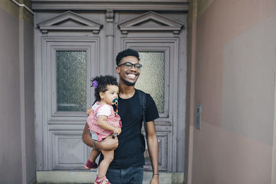 Full length of father and son standing at home