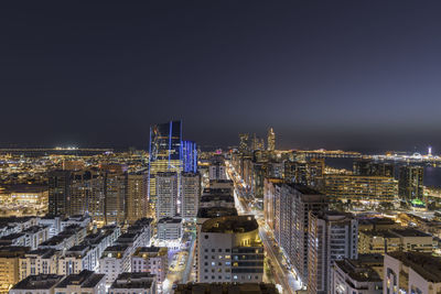 High angle view of illuminated buildings against clear sky at night