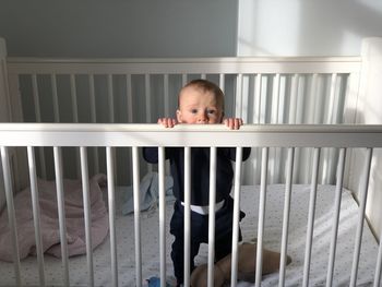 Portrait of boy standing by railing