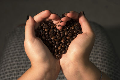 Cropped hands holding roasted coffee beans