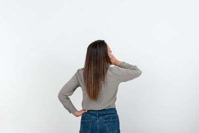 Rear view of woman standing against white background