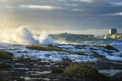 Water splashing in sea against sky