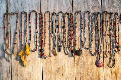 Bead necklaces hanging on wood for sale in market