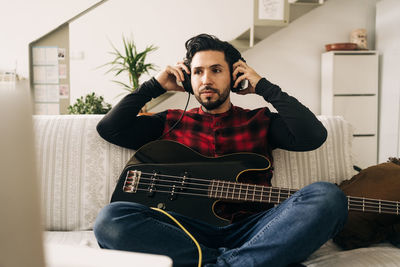 Young man sitting on sofa at home