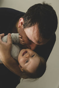 Father kissing baby at home