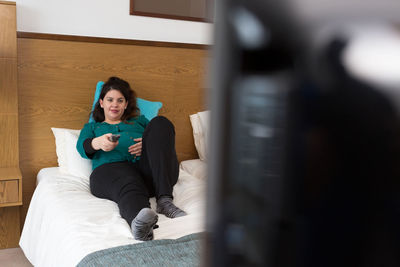 Full length of woman sitting on wall