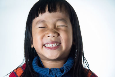 Close-up portrait of smiling mid adult man against white background
