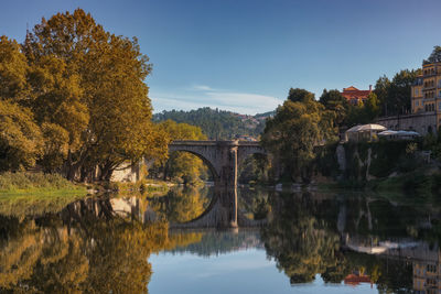 Arch bridge over river against sky