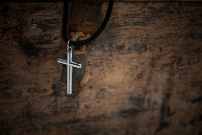 Close-up of cross hanging on wood