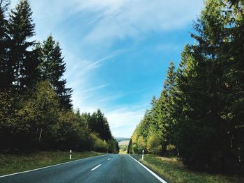 Road amidst trees against sky