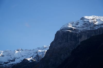 Scenic view of snowcapped mountains against clear blue sky