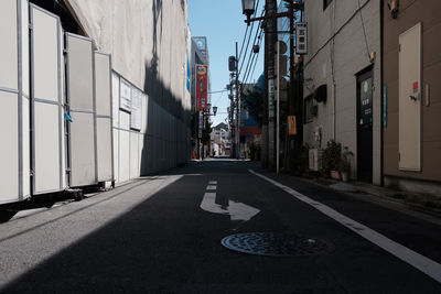 Road amidst buildings against clear sky