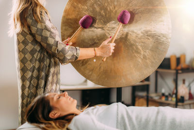 Playing gong in sound bath therapy